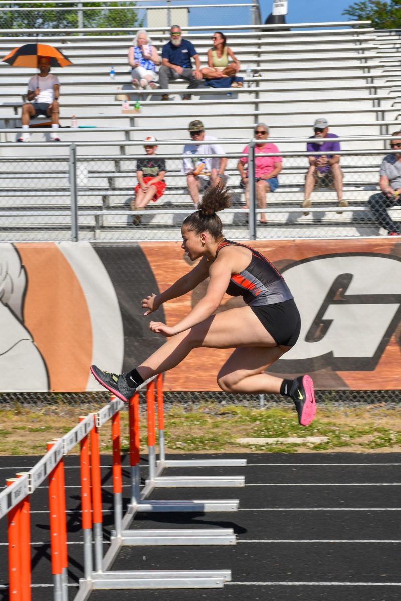 Nautica York takes the leap over the hurdles, attempting to clear it. 