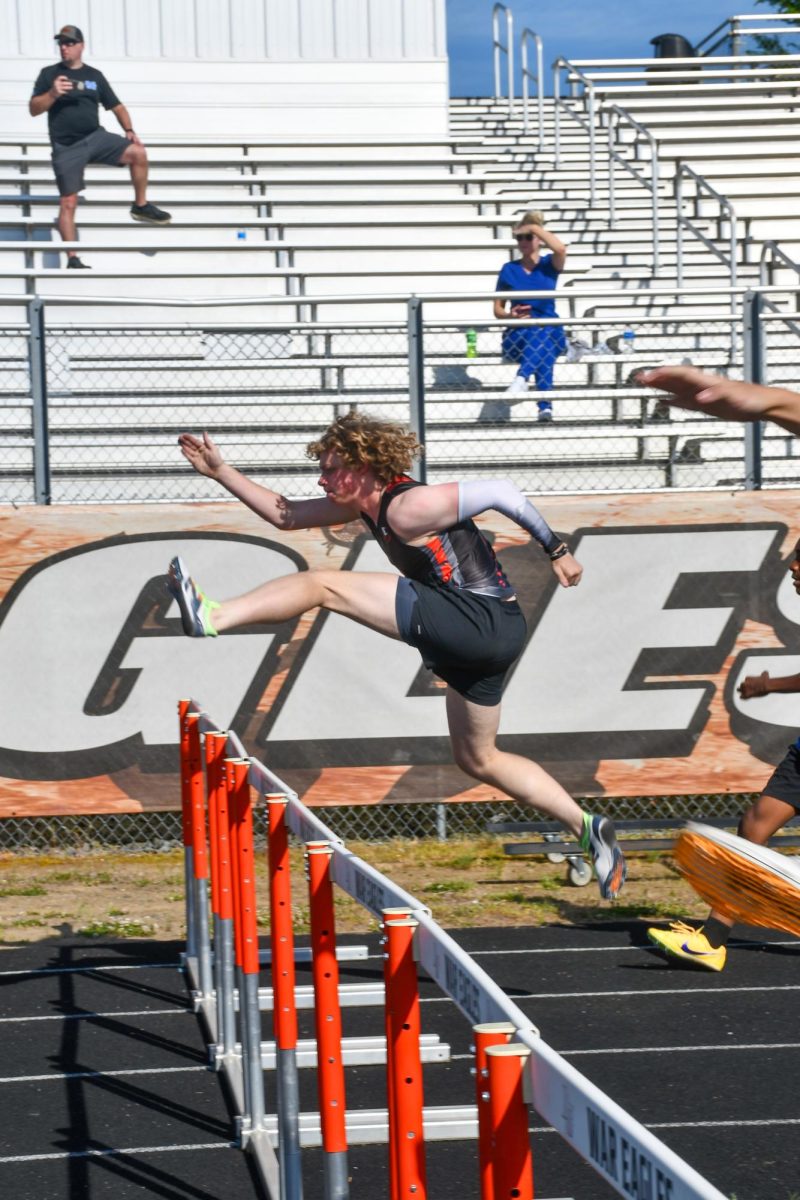 John Coley pushes off to make the jump over the hurdles. 