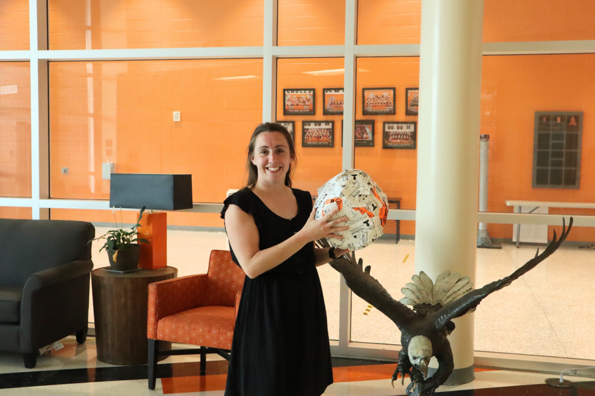 Administrative assistant Courtney McCabe holds her stickerball made up entirely of visitor stickers collected over three years.