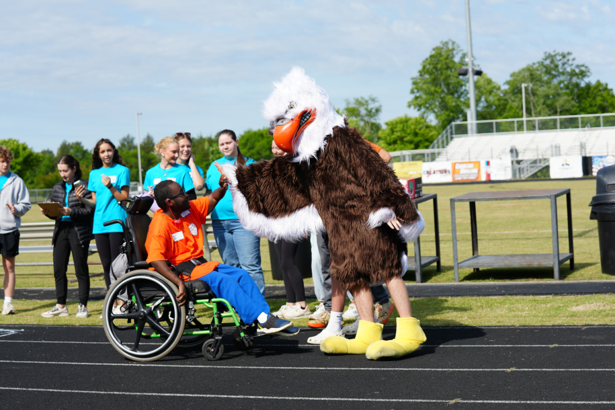 Joshua Wilds receives a high five from Davie High School's mascot after wheeling himself across the finish line. While this was not Wilds first special olympics, it was the first time he competed in the unassisted wheelchair race and he came in first. 