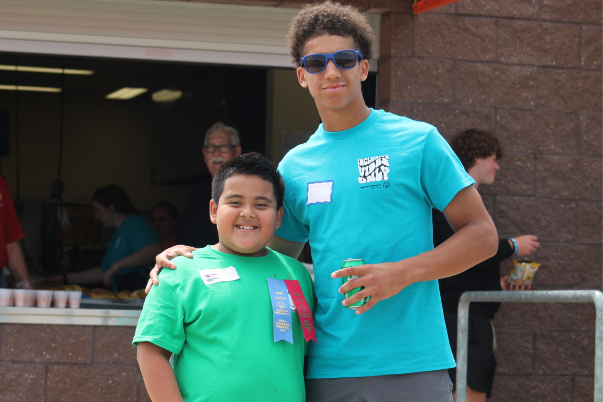 Preston Young poses enjoys a refreshment with his ribbon-winning buddy Johan, who placed in the 100 meter run and softball throw. 