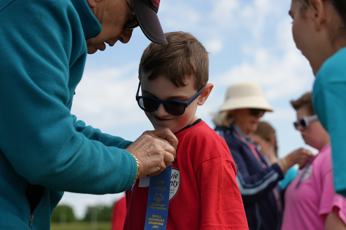 Shady Grove's Charlie admires his first place ribbon being pinned to his shirt, after sprinting his way through the finish line in the 50 meter sprint. His fans dressed up in matching Charlie shirts to show their encouragement and faith in him. 