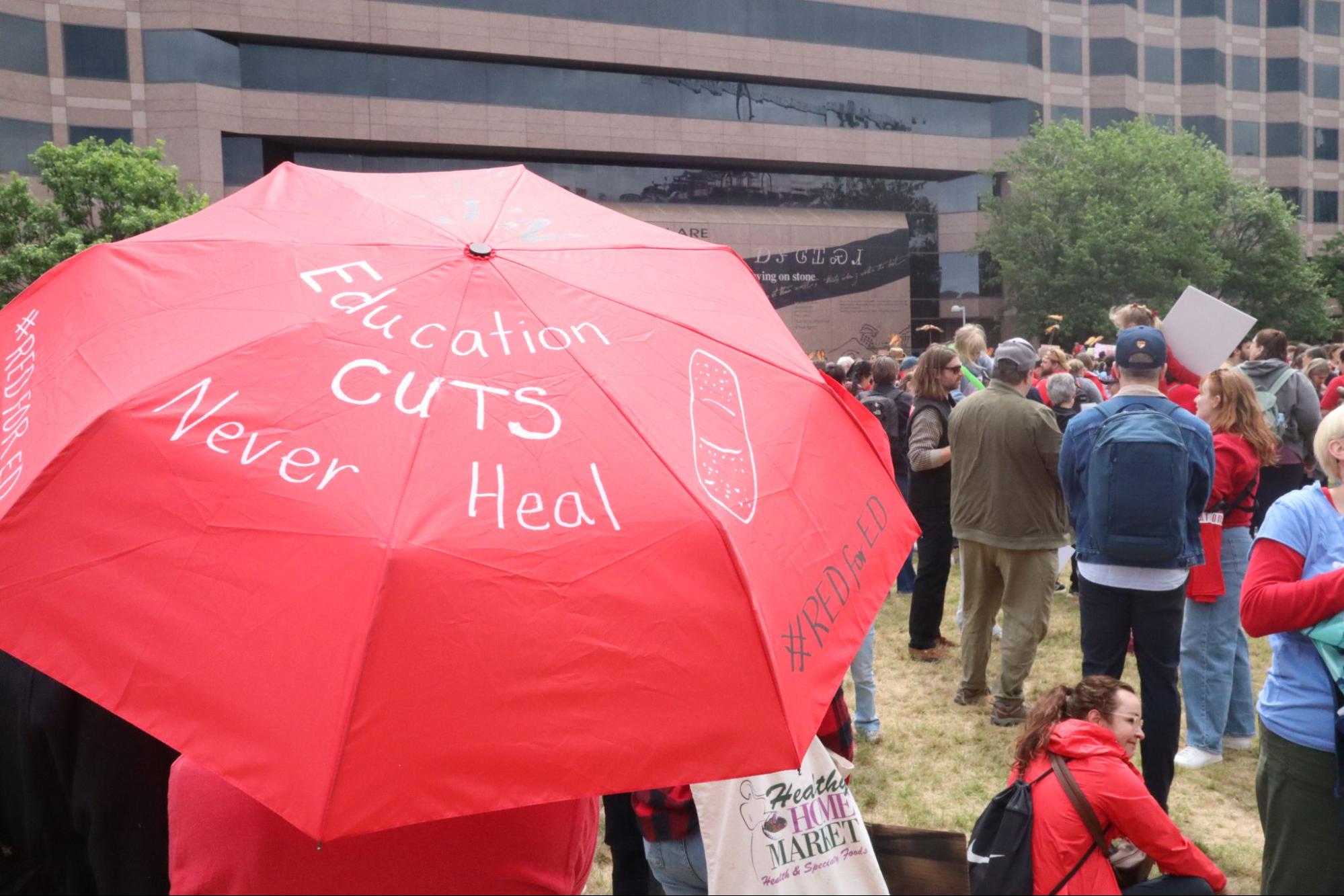 One protester carries an umbrella with the message "Education Cuts Never Heal." As part of the assembly, teachers advocated for more funding for students, teachers, and school districts. | Photo courtesy Matt Barker