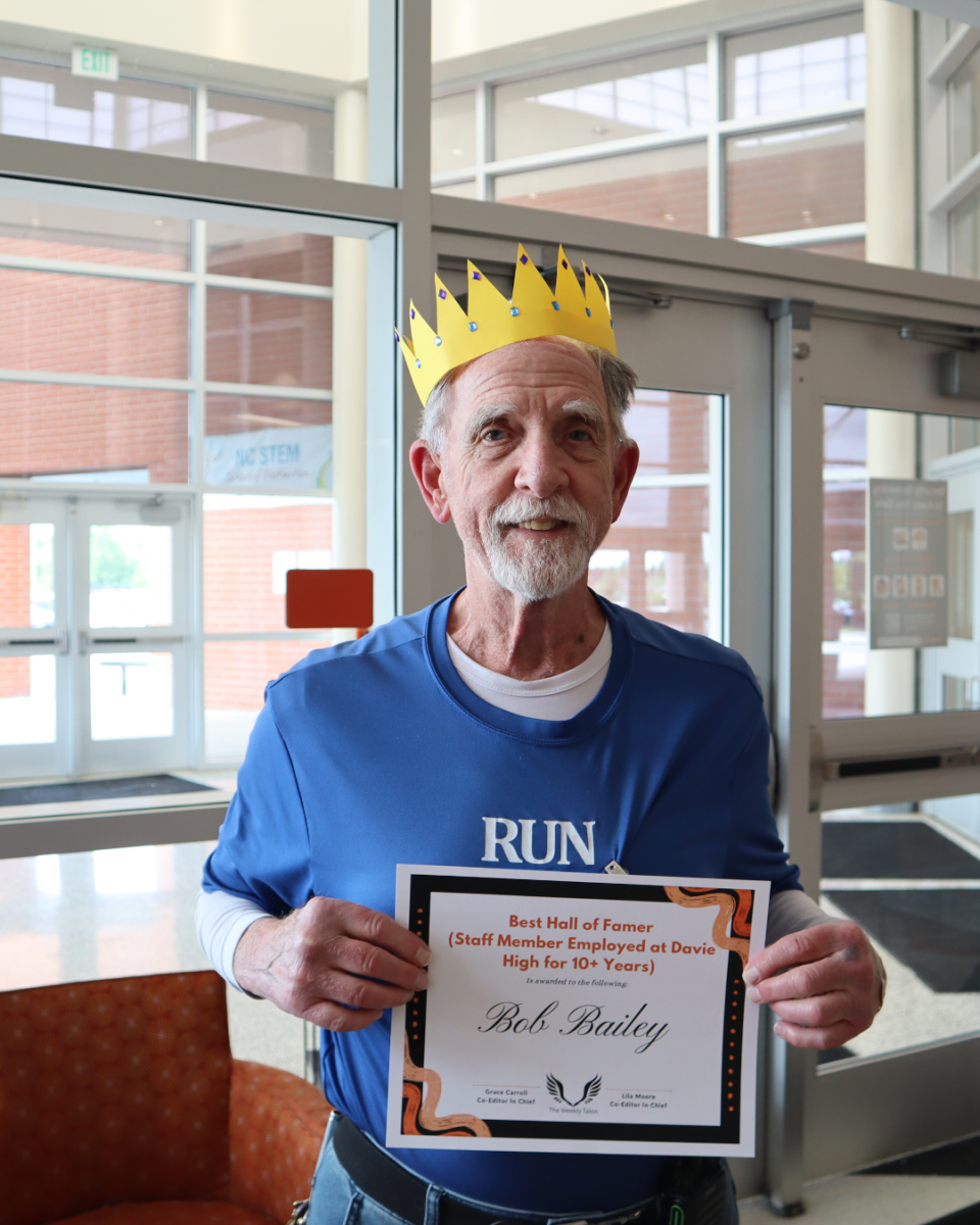 Bob Bailey, custodian extraordinaire, poses in the cafeteria with his Student Choice Award