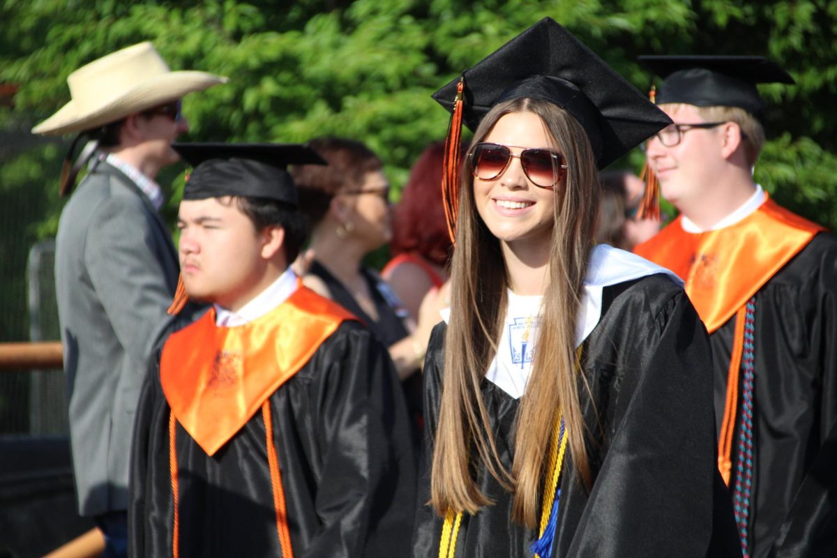 Davie High seniors walk from the high school to the football stadium as they prepare for their commencement ceremony. As is tradition, students walk to the football stadium through a "tunnel" of teachers who cheer them on and clap for them as they pass by.