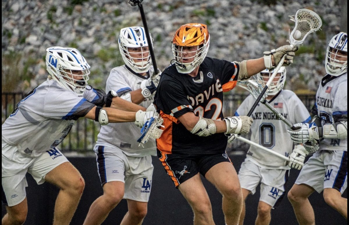 Senior Jack Pisciotta makes a drive for goal, dodging the Lake Norman Defenders, while keeping possession of the ball. 